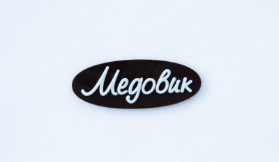 Декор Фигурный темный  Логотип "Медовик"(овал) с надписью из белой глазури  ТG-0028